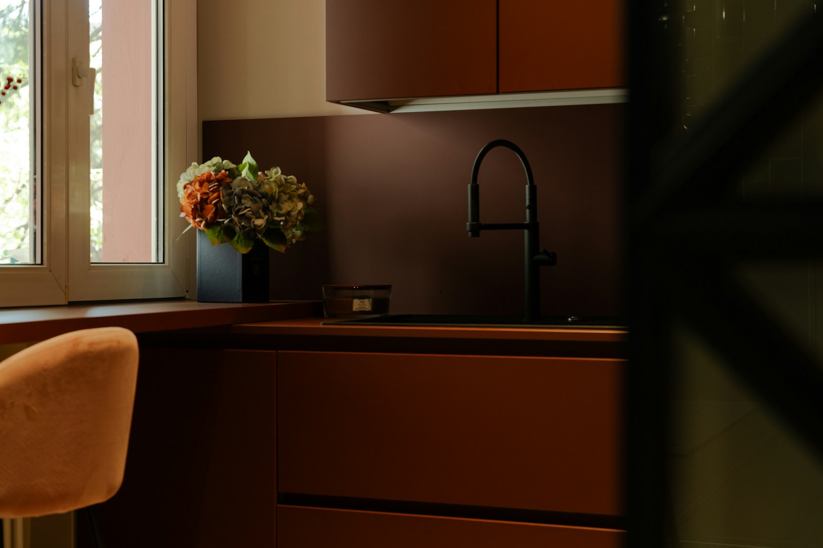 a vase of flowers sitting on a counter next to a window