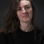 A woman with long hair and a black shirt